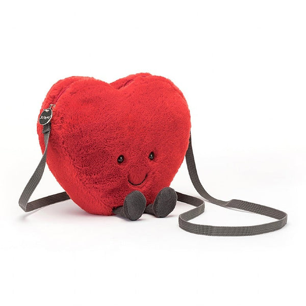 Soft fleece red heart shaped crossbody bag with smiley face and little legs with corduroy. Zip closure and straps. Cuddly plush toy bag.