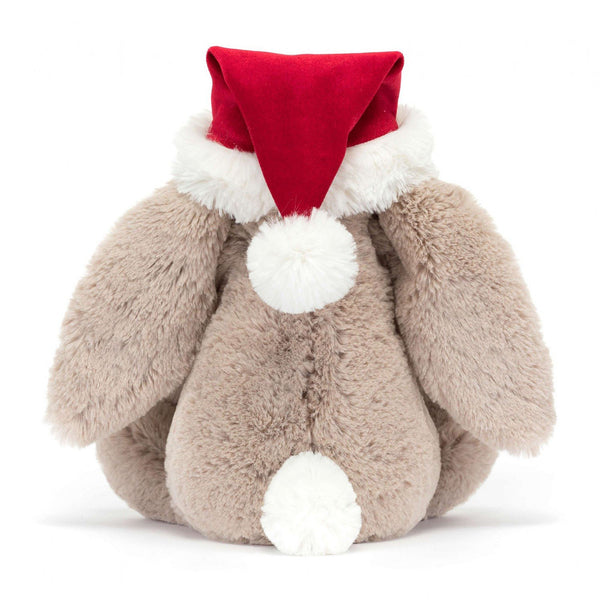 Bunny rabbit cuddly plush toy in light beige fur and santa hat in red and white