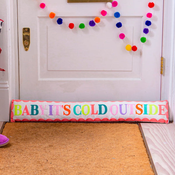 white draught excluder with colourful #baby it's cold outside# embroidery