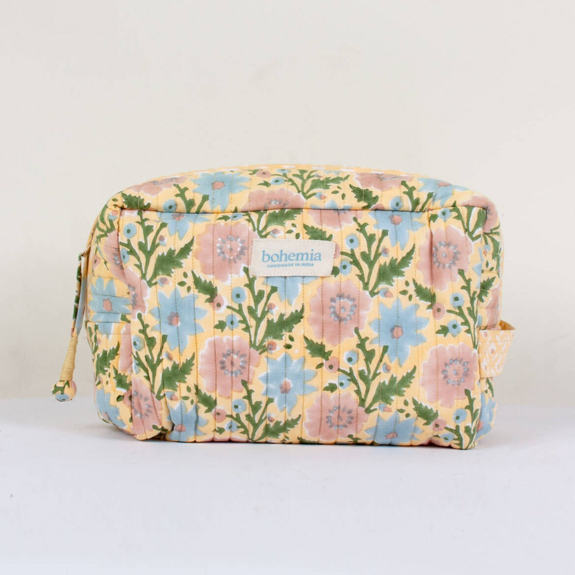 quilted wash bag in pastel yellow with blue and pink flower print