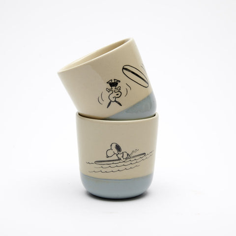 natural colour stoneware beaker with blue glaze bottom and surfing snoopy illustration on both sides