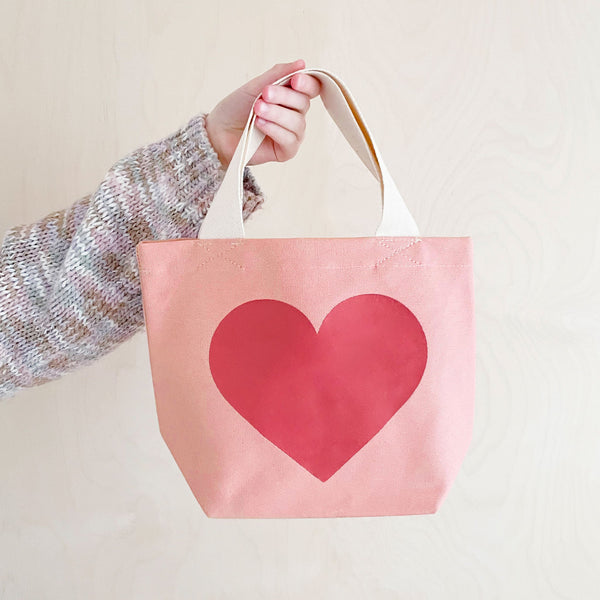 Small pink cotton canvas tote bag with big dark pink love heart print and white handle