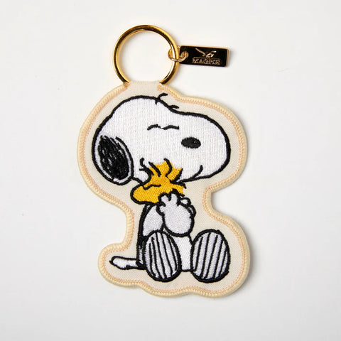 Embroidered applique key charm in cream with Peanuts Snoopy hugging yellow woodstock