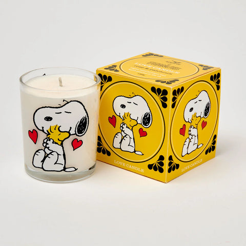 Rose and Patchouli scented candle in a glass jar with Snoopy hugging woodstock illustration, with a yellow box with the same illustration 