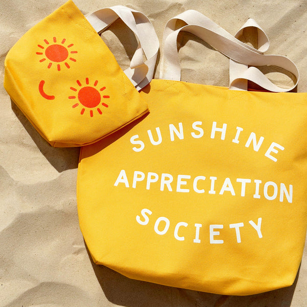 Yellow canvas tote bag with sunshine appreciation society slogan and white handle